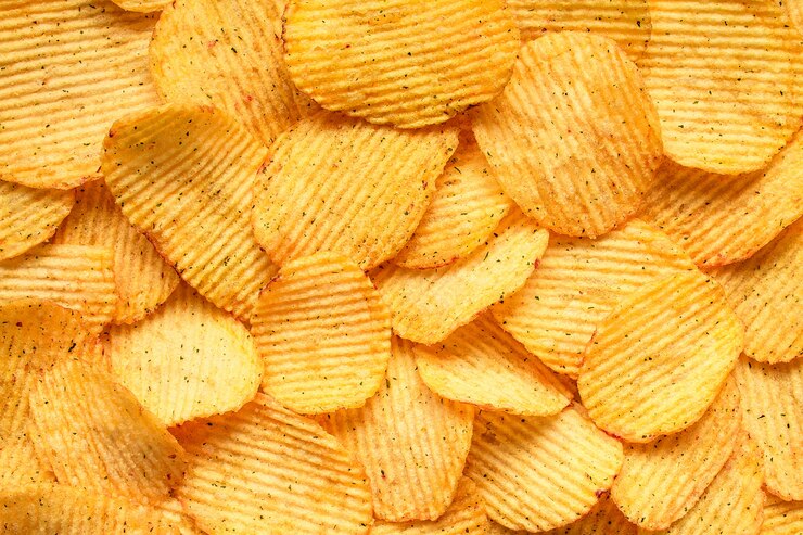 Photo yellow salted potato chips as background