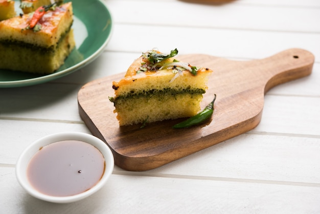 Yellow Sandwich Dhokla is een Indiase hartige snack gemaakt van kikkererwtenmeel of rijstmeel, afkomstig uit Gujarat. Geserveerd met groene en tamarindechutney. selectieve focus