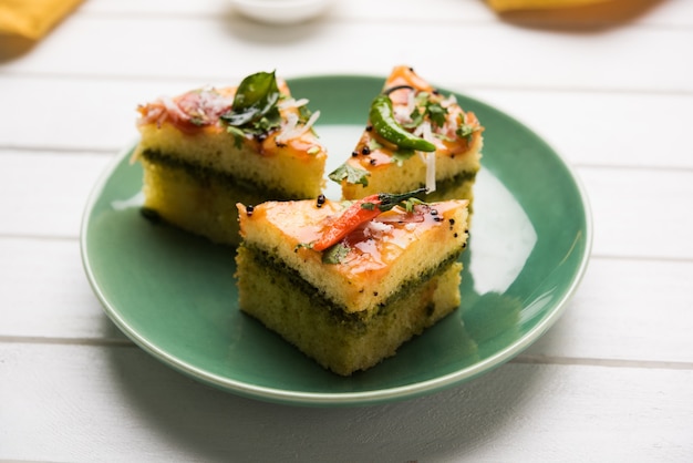 Yellow Sandwich Dhokla is an Indian savoury snack made of chick pea flour or rice flour, Originated in Gujarat. Served with green and tamarind chutney. selective focus