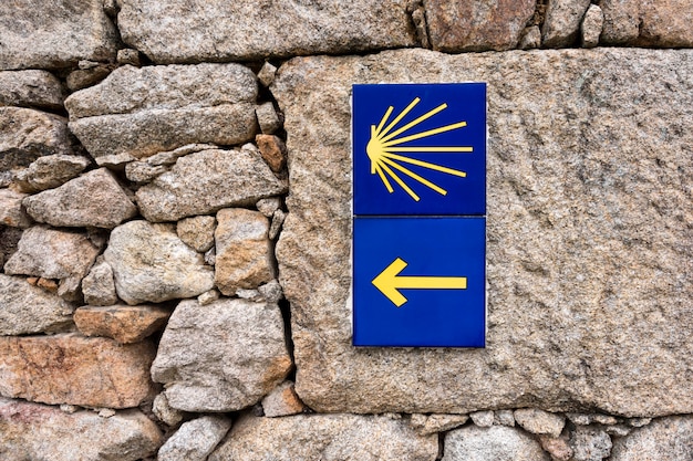 Yellow scallop shell, touristic symbol of the Camino de Santiago showing direction on Camino Norte in Spain