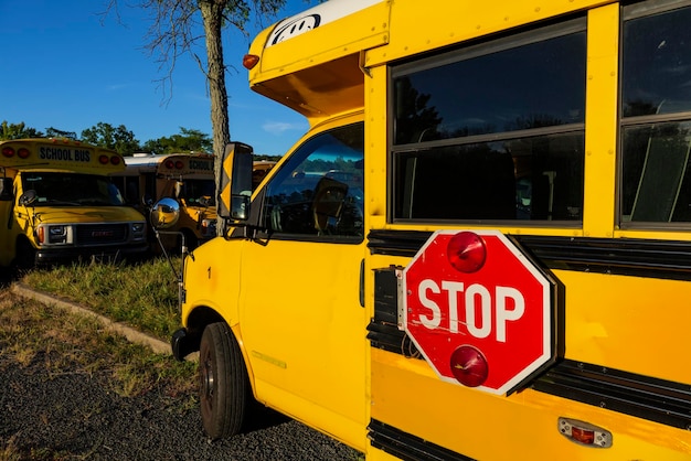 Yellow school bus against blue sky stop sign on a side school bus parking back to school concept