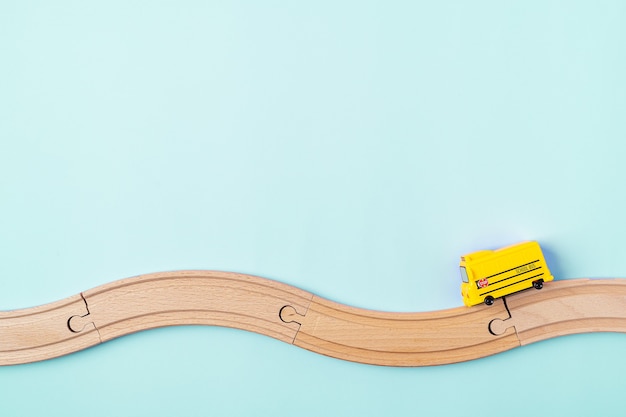 Yellow school bus model and wooden road