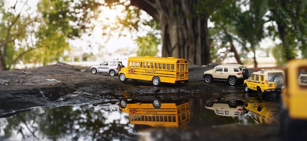 Фото Игрушечная модель желтого школьного автобуса на проселочной дорогеназад к школьному концептуальному фону