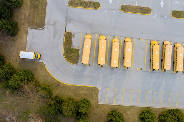 Yellow school buses in parked the parking lot of the day
