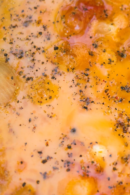 Yellow scrambled eggs with pepper close up background