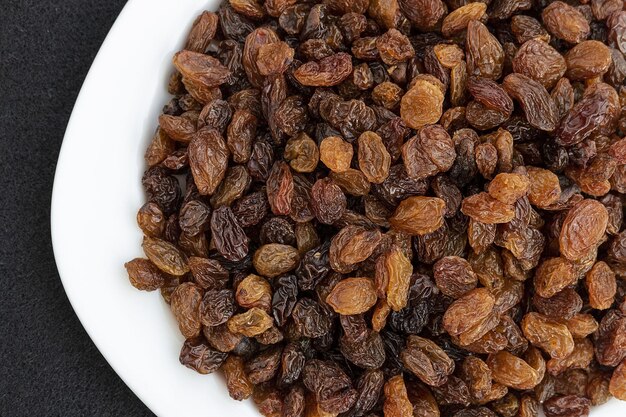 Yellow seedless raisins on a plate closeup