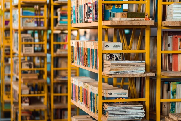 A yellow shelf with books on it that says the book's name is on the top shelf