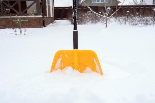 a yellow shovel standing in the snow
