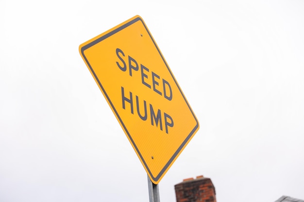 A yellow sign that says speed bump on it