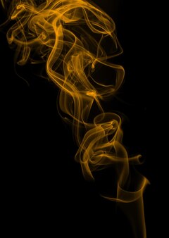 Estratto di fumo giallo su sfondo nero, design del fuoco