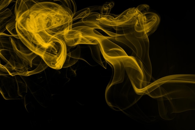 黒の背景の火のデザインに黄色の煙の抽象的な