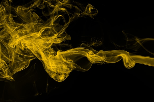 Yellow smoke on black background, abstract movement