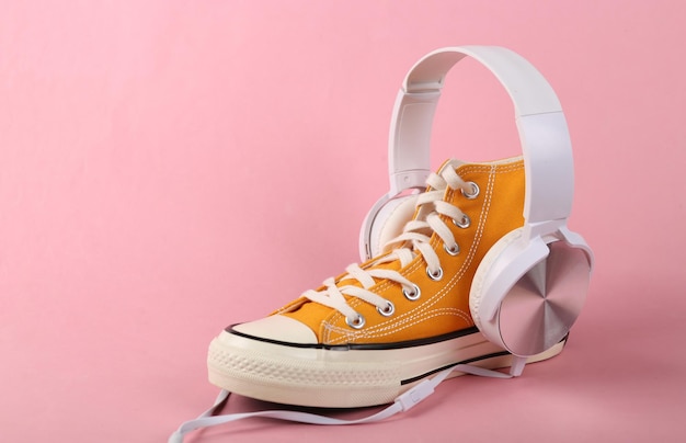 Yellow sneaker with headphones on a pink background Minimalism Concept art