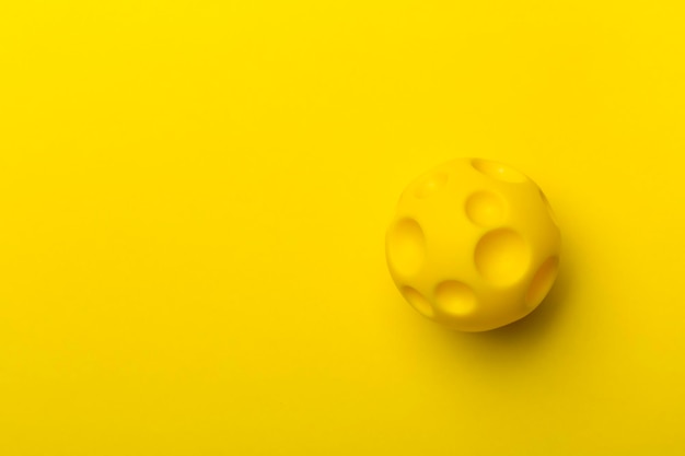 Yellow spiky ball toy for pet on color background