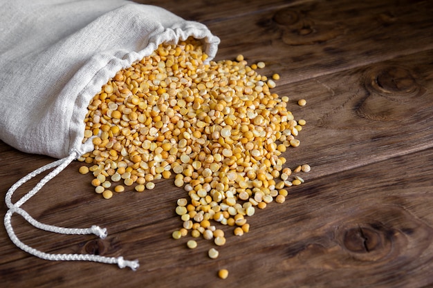 Yellow split peas in a bag on a wooden table