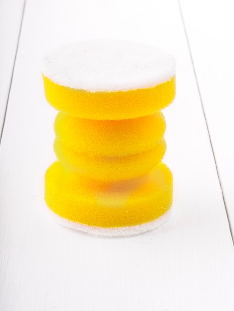 Yellow sponges for washing dishes on white wooden backgroud