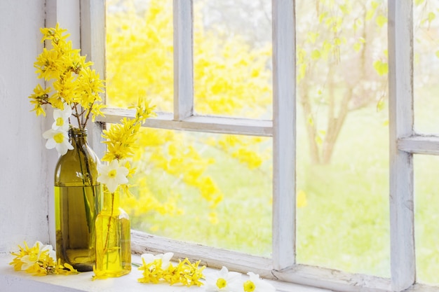 Yellow spring flowers on old white windowsill