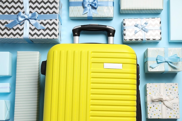 yellow suitcase with gifts on a blue background
