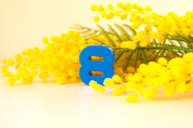Фото Желтая солнечная открытка к женскому дню 8 марта ветки мимозы и число восемь концепция праздников и пожелания доброго утра
