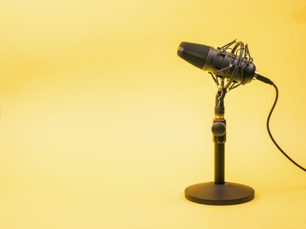 A yellow surface and a modern condenser microphone