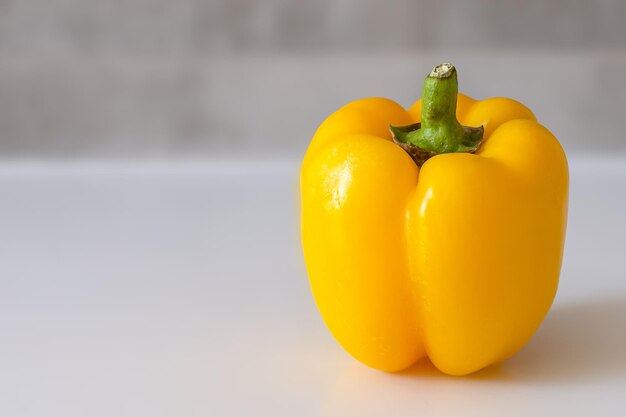 Yellow sweet paprika pepper closeup on a gray background copyspace