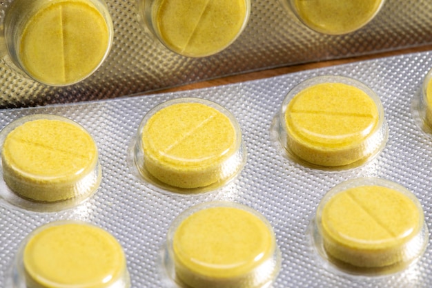 Yellow tablets in a close-up blister. medical drug