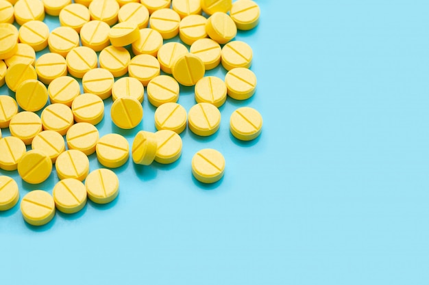 Yellow tablets of Paracetamol on blue background.  