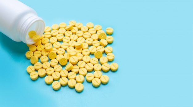 Yellow tablets of Paracetamol on blue background.  