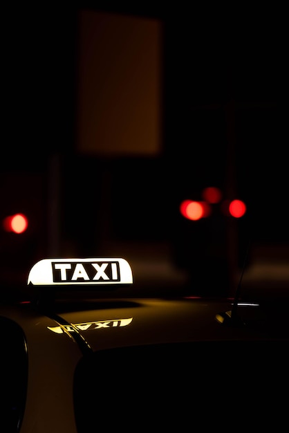 Yellow taxi car parked on a city street at night