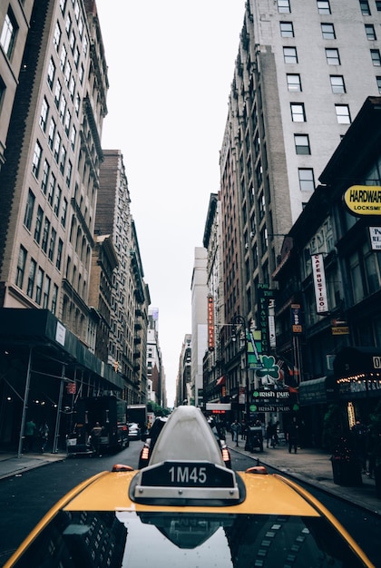 写真 街の建物の真ん中にある道路の黄色いタクシー