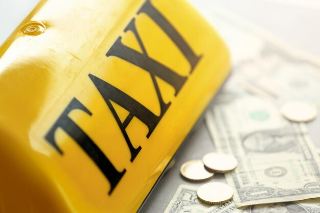 Yellow taxi roof sign with money closeup