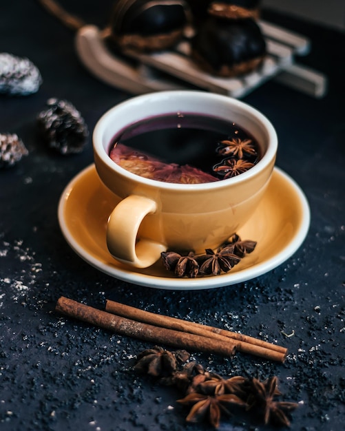 Yellow tea cup composed of cinnamon and other ingredients on a black background