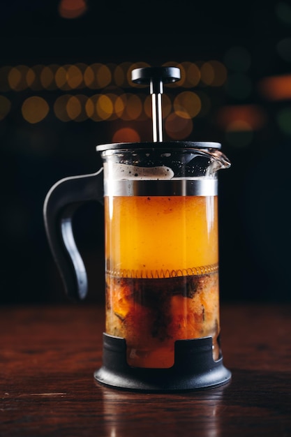 Yellow Tea in french press on a wooden table