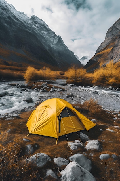 Желтая палатка на берегу горной реки в горах