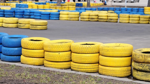 Yellow tires are stacked on the side of a track.