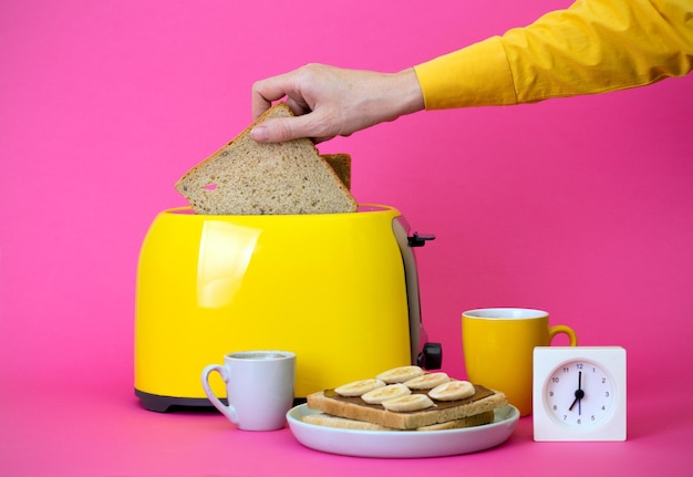Желтый тостер на розовом фоне