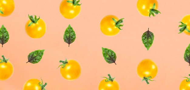 写真 オレンジ色の上面図で分離された黄色いトマトとバジルの葉フルーツパターンフラットレイ