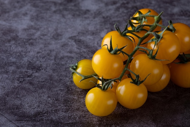 Yellow tomatoes on grey background