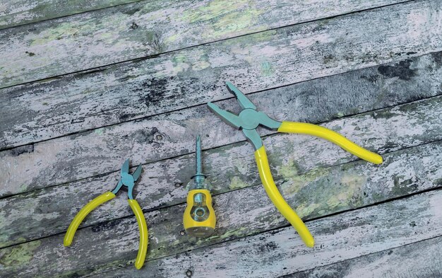 Photo yellow tools set craftsman isolated on wood background screwdriver cable cutters pliers