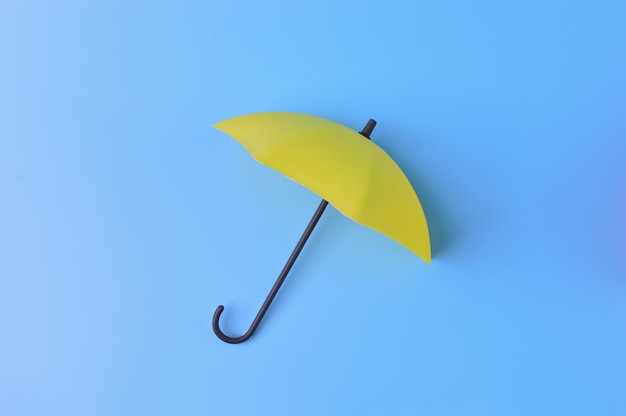 Yellow toy umbrella isolated on a blue background