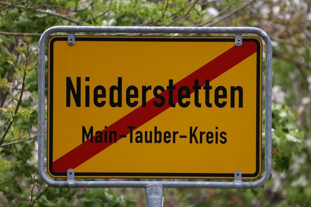 Photo yellow traffic sign with local town names niederstetten in a maintauber district germany