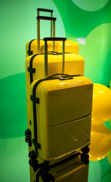 Photo yellow travel suitcases on a green ball background