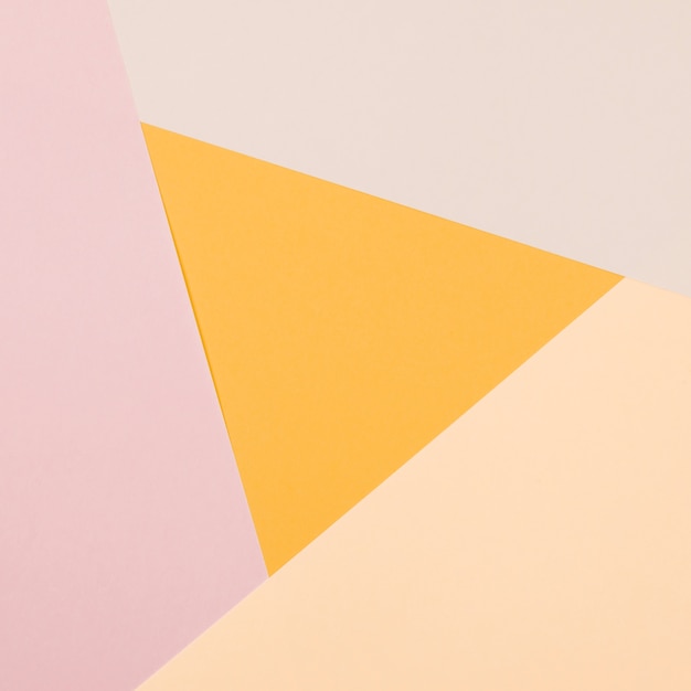 Yellow triangle with colorful paper geometric flat lay background