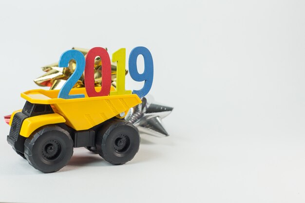 Желтый грузовик держит номер 2019 на белом фоне.