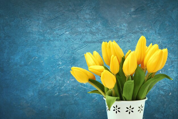 Yellow tulips bouquet in  white vase.