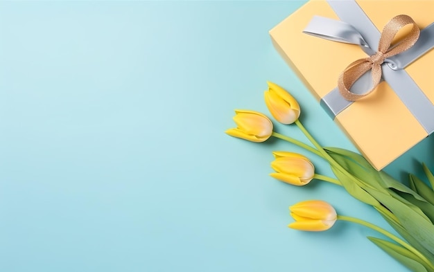 Yellow tulips in a gift box with a gift on a blue background