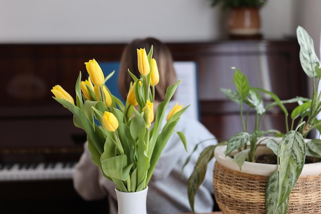 テーブルの上の黄色いチューリップと観葉植物