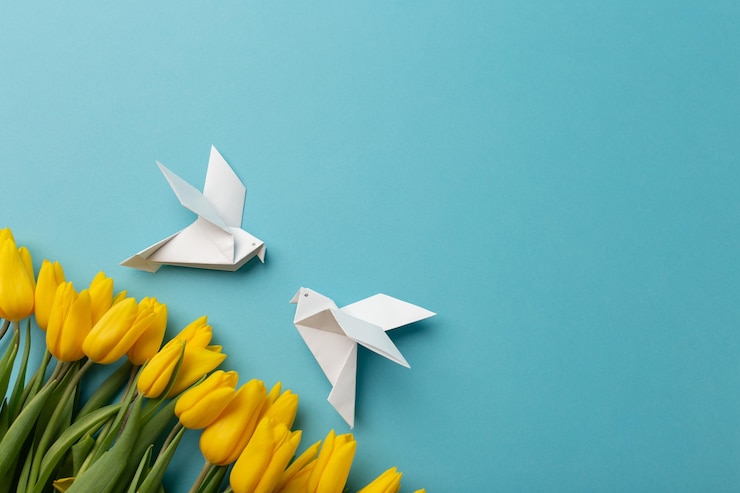 Photo yellow tulips and two white birds as a symbol of peace on a blue background