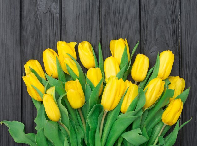 Yellow tulips on wooden surface