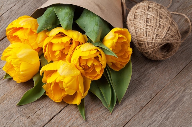 Yellow tulips over wooden table